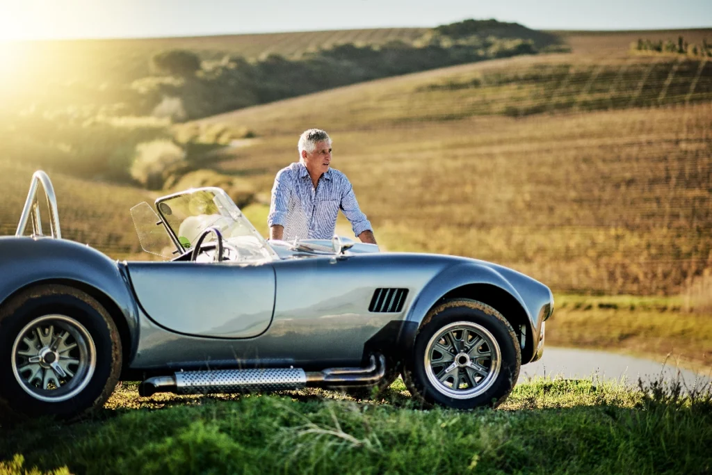 Man with a classic sports car in the countryside